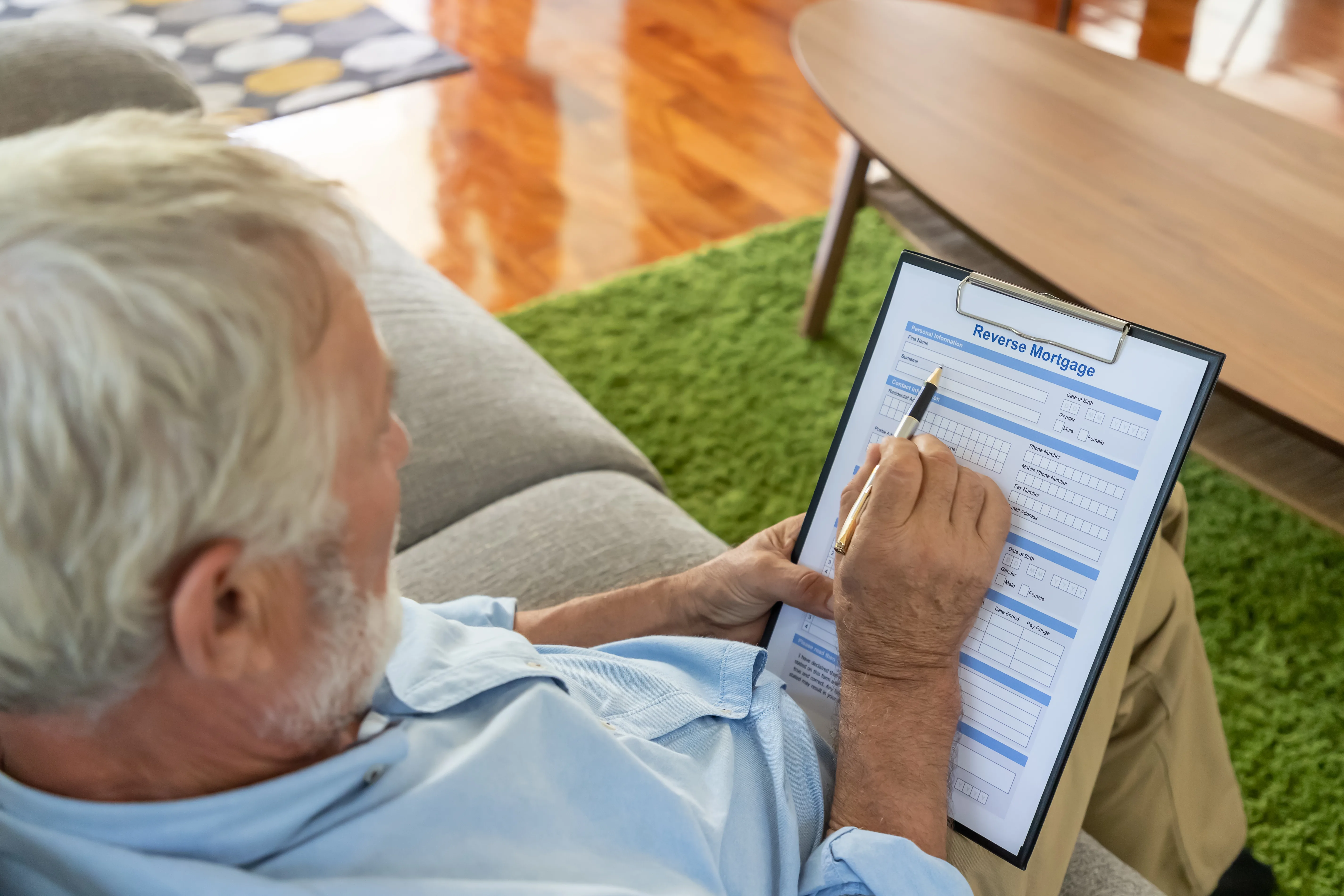 Senior old man elderly reading and examining reverse mortgage ap Senior old man elderly reading and examining reverse mortgage application form