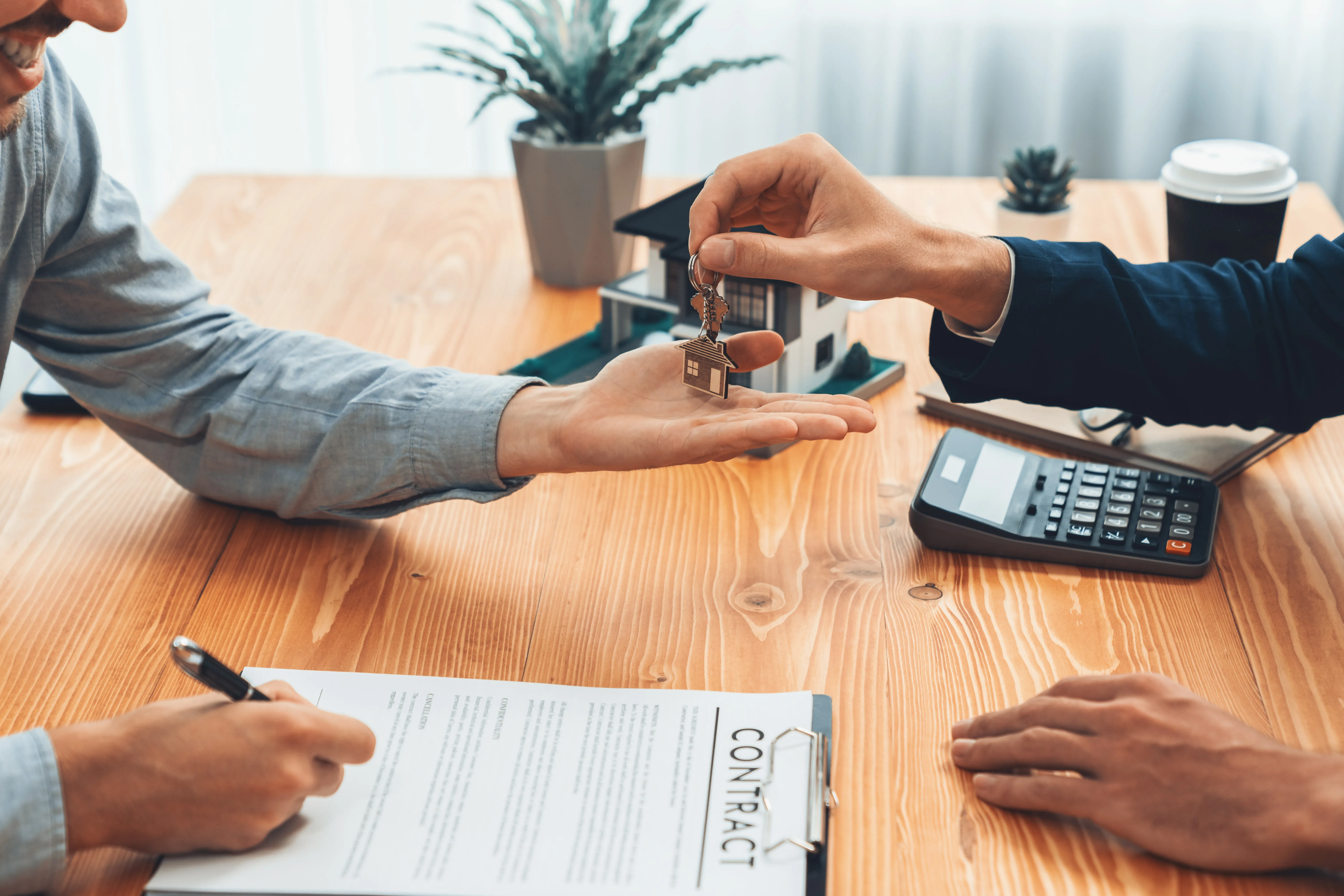 Real estate agent handing house key to buyer. Entity Real estate agent handing house key to buyer after signing rental least contract during house loan meeting. Successful property sale purchase agreement for new home ownership. Entity